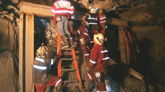 Rescuers searching for  trapped workers at a giant U.S.-owned gold and copper mine in Indonesia spotted six bodies Saturday but weren't able to immediately retrieve them because of falling debris, a company official said.